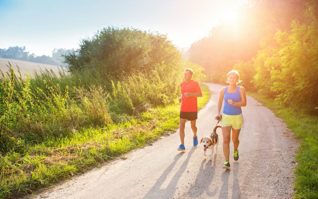 Older couple running with their dog